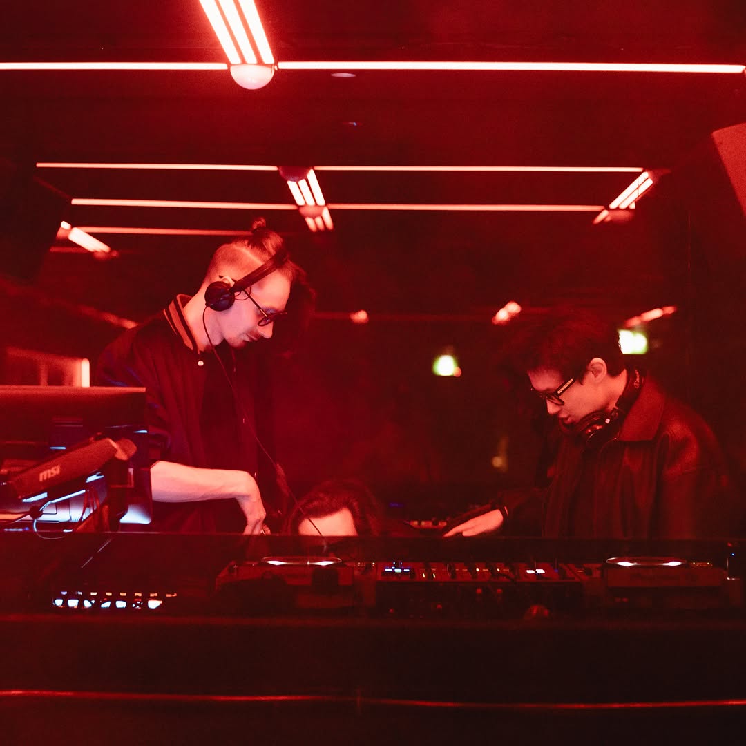 MIOKASTA and a guest DJ performing in a red-light club